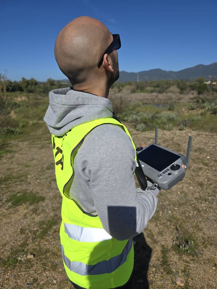 Pilota con radiocomando che segue il drone in volo